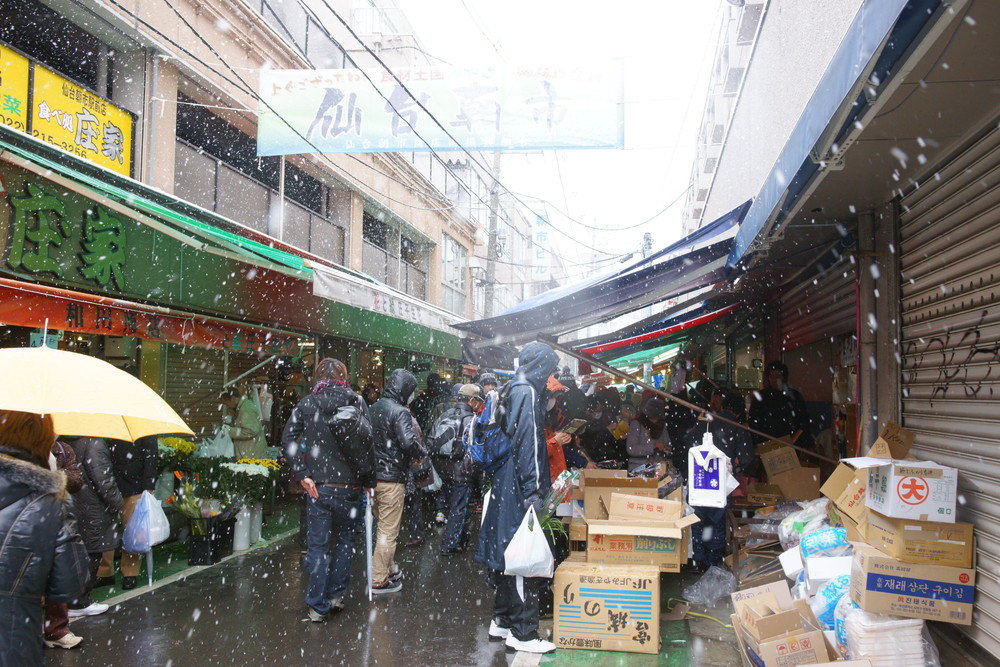 雪の振る仙台朝市で買い出しをする人々