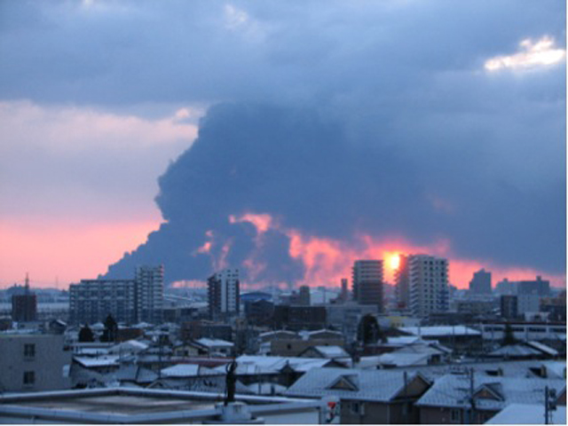 震災翌朝、仙台港の石油コンビナートから立ち上がる黒煙